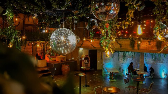 Foto vom Firehouse Eventraum von oben, dekoriert mit Pflanzen und Discokugeln